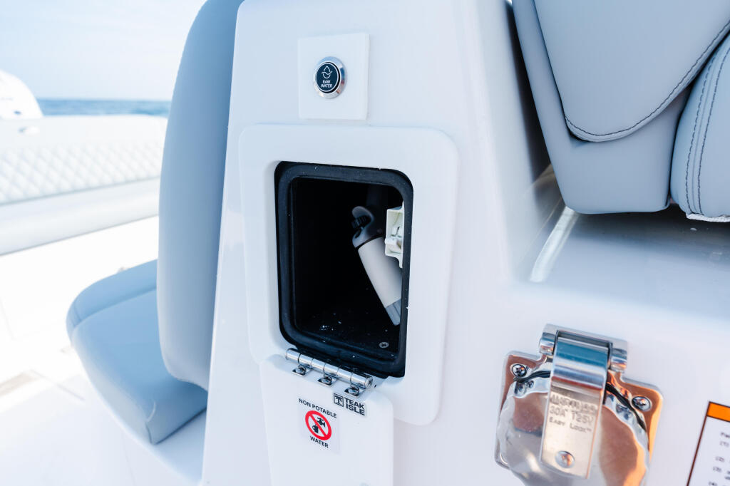 Starboard console panel with livewell access door and anchor light switch on white fiberglass cabin