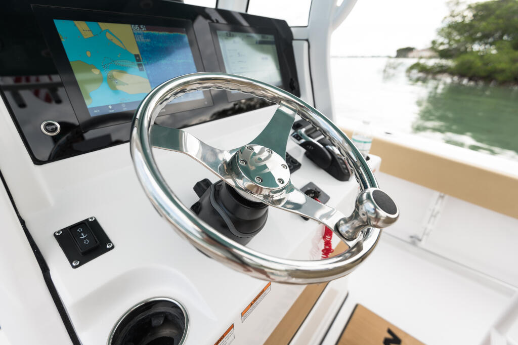 Stainless steel steering wheel at helm with GPS navigation display and control panel
