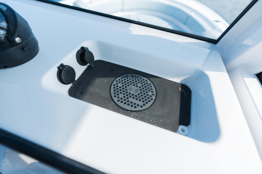 Built-in wireless phone charger and speakers mounted in the helm console of a center console boat