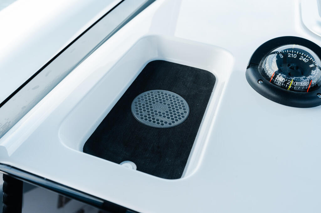 Boat helm dashboard with compass and speaker detail in white and black finish