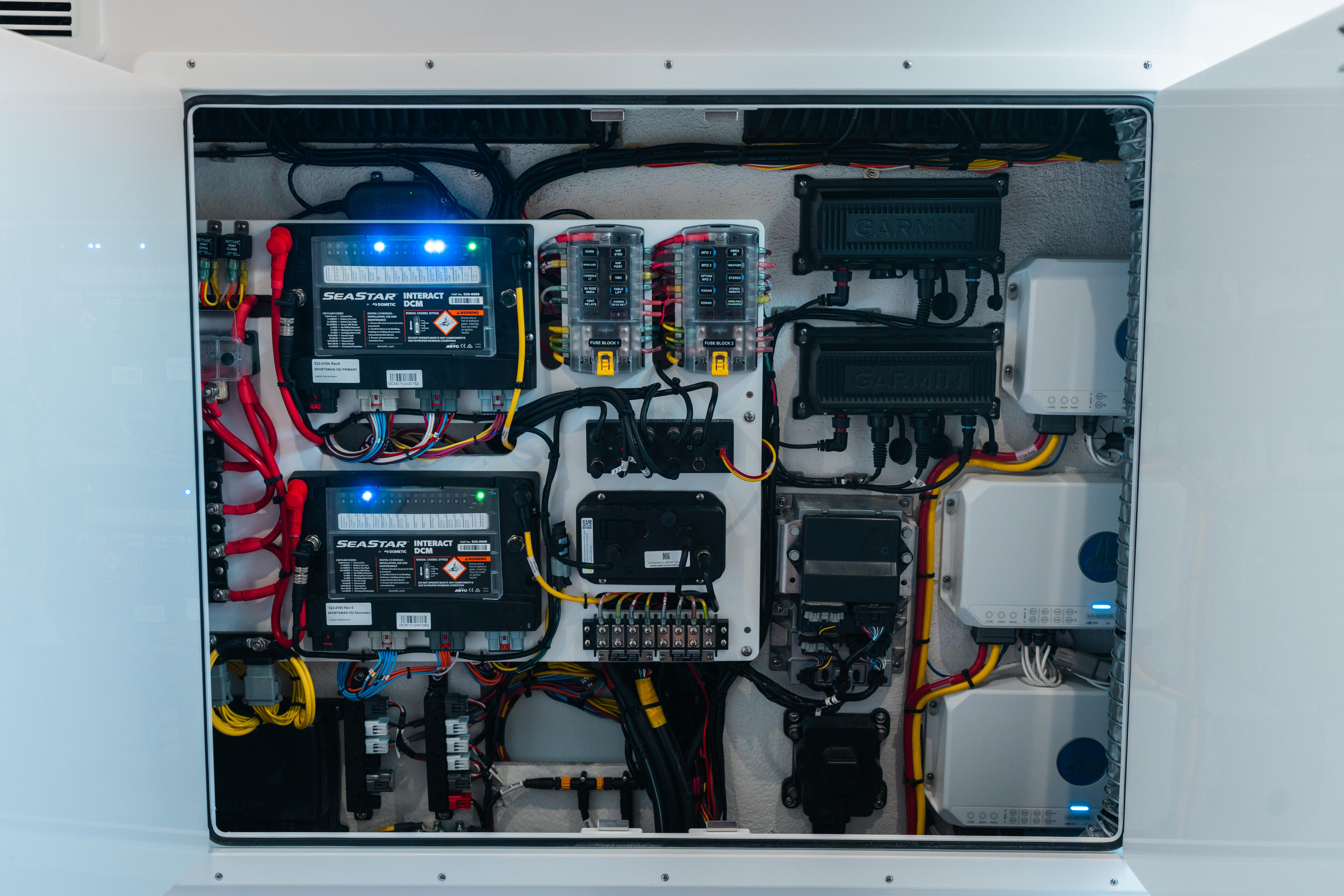 Overhead view of boat electrical panel with multiple circuit breakers, battery chargers, and color-coded wiring