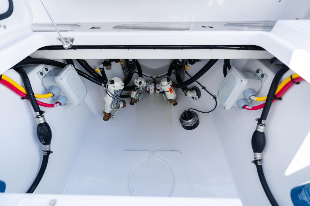 Overhead view of boat engine compartment with dual outboard motors, battery systems, and electrical wiring