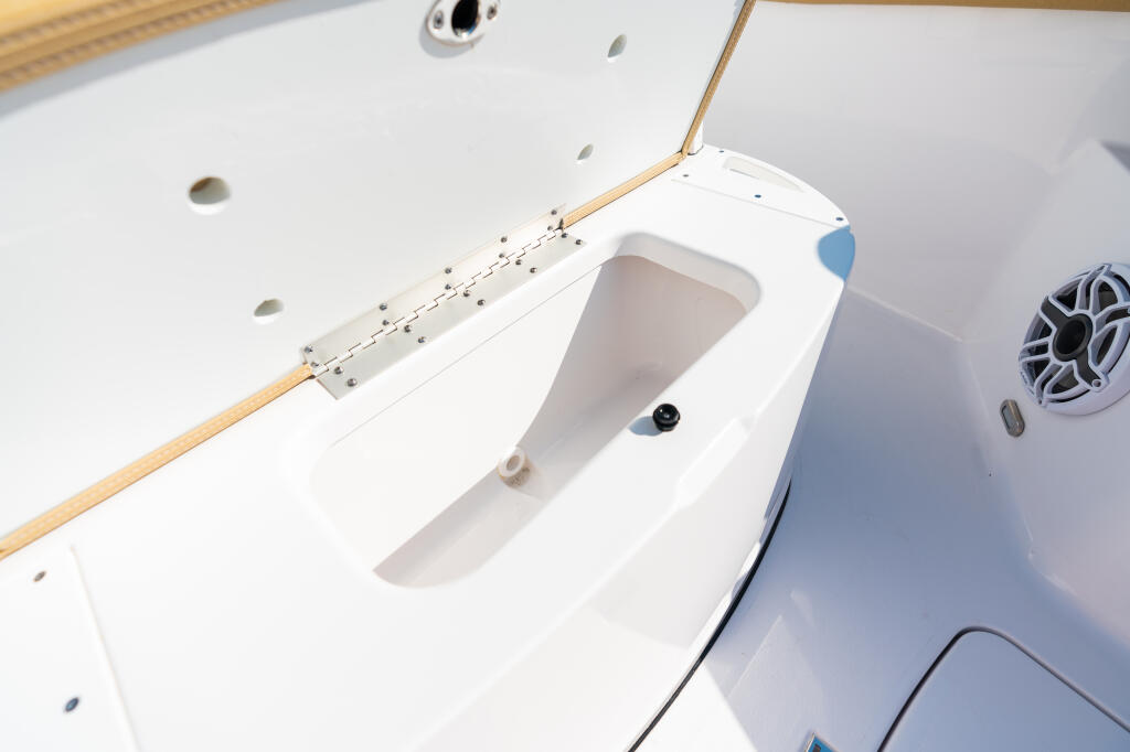 Overhead view of center console deck showing white gel-coat, wooden railings, and built-in cooler storage