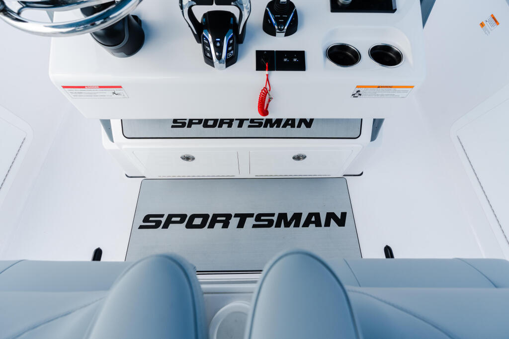 Overhead view of Sportsman boat helm with control console, seating, and accessories displayed on white deck