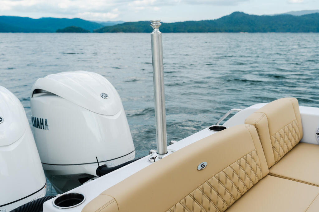 Yamaha outboard engines and tan quilted seating on a boat with mountain lake in background