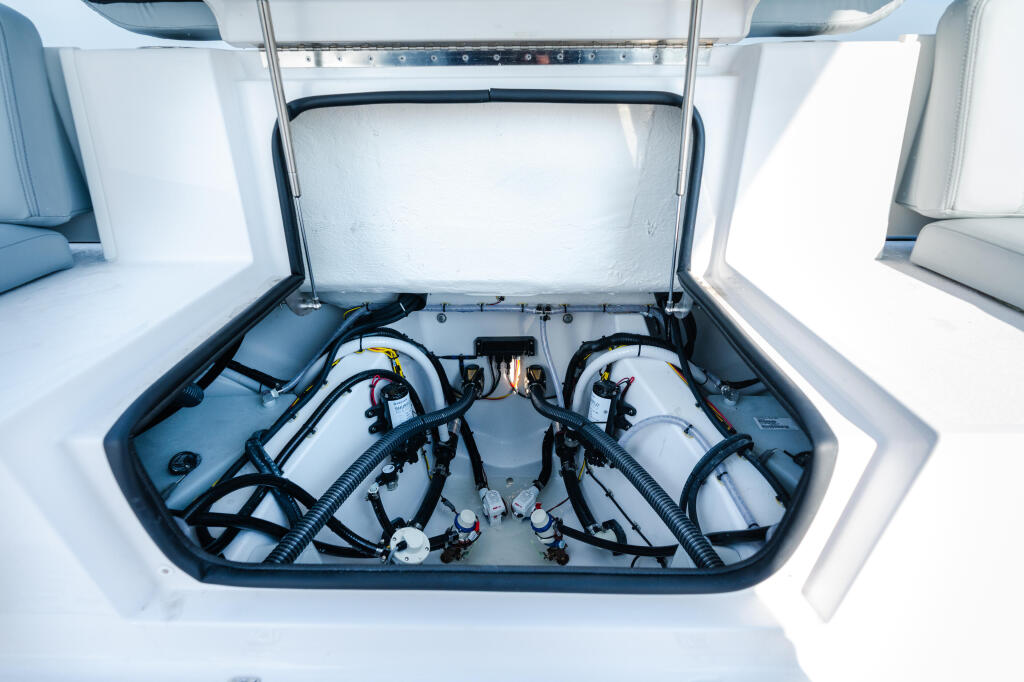 Dual outboard engines with fuel tanks and plumbing systems visible under open engine hatch