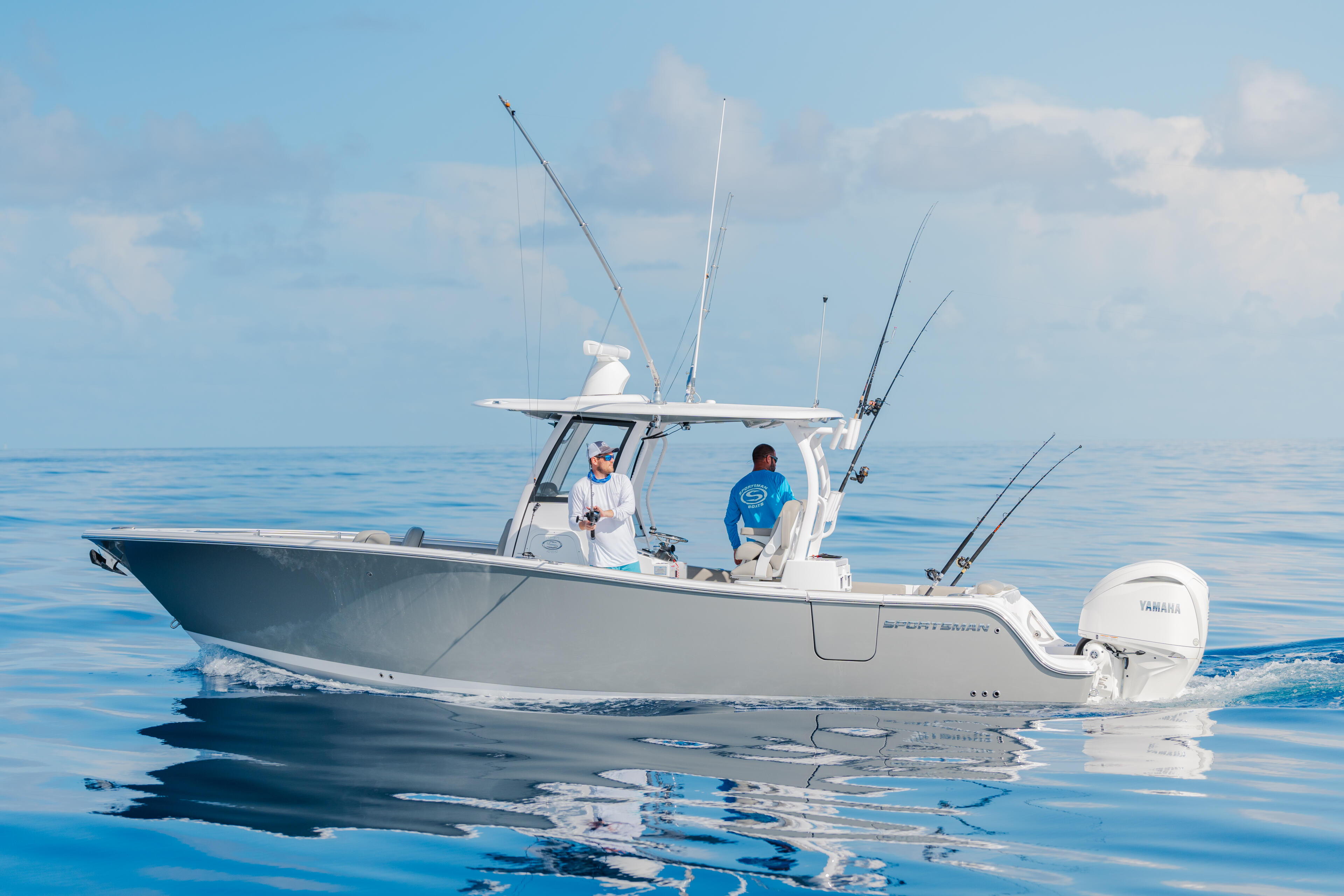 Two anglers on a sportfishing boat equipped with multiple fishing rods in calm offshore waters