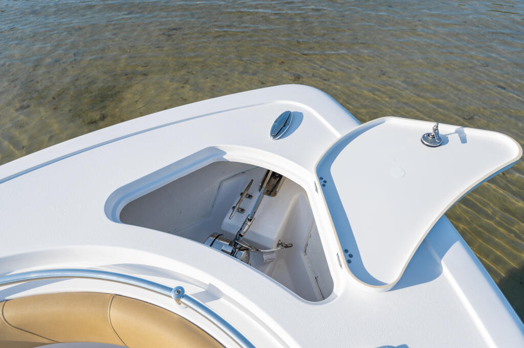 Open center console bow with anchor locker access and ventilation ports in white fiberglass