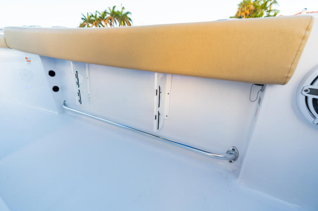 Tan canvas shade covering storage compartments and rod racks along the gunwale of a white center console boat