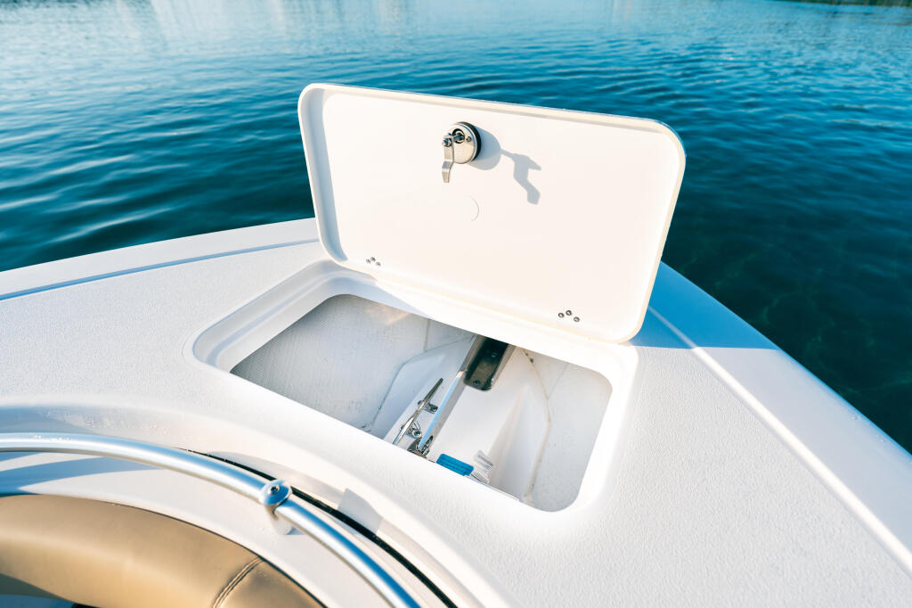 Open cooler storage compartment with latch on white boat deck