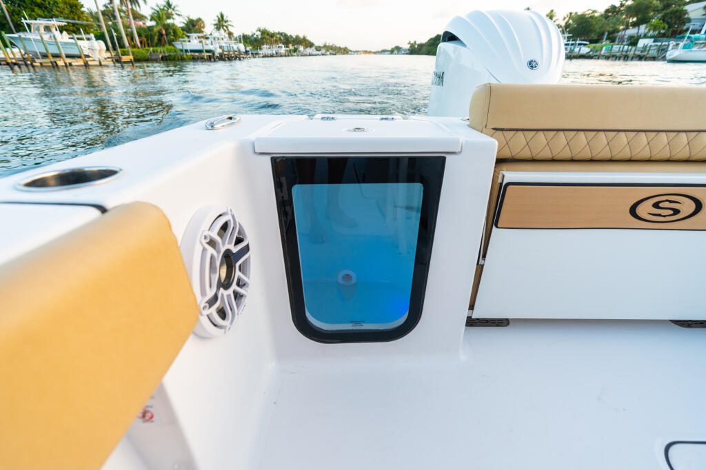 Center console boat deck with built-in 25-gallon livewell and white hard-top, moored in tropical marina
