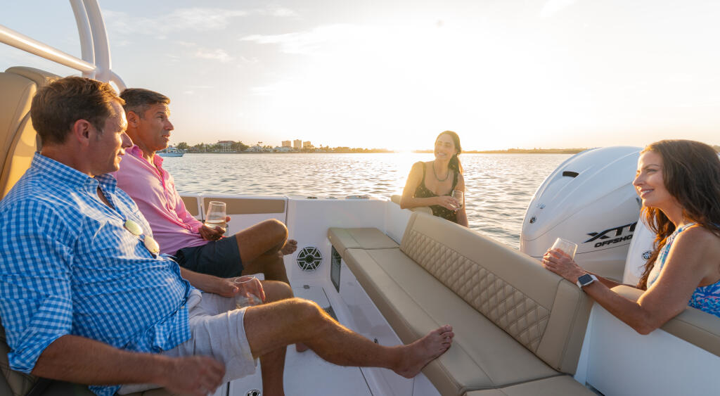 Group of friends enjoying drinks and conversation on a boat during golden hour sunset cruise