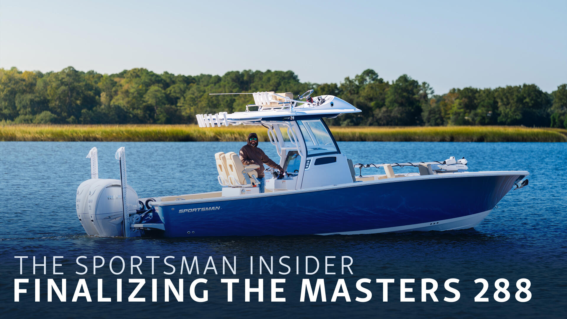 Blue and white Sportsman boat running in coastal waters with a captain at the helm and marsh landscape behind