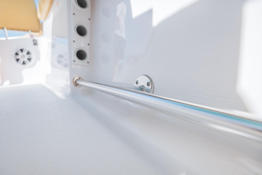 Polished chrome toe rail with mounting hardware on boat gunwale interior