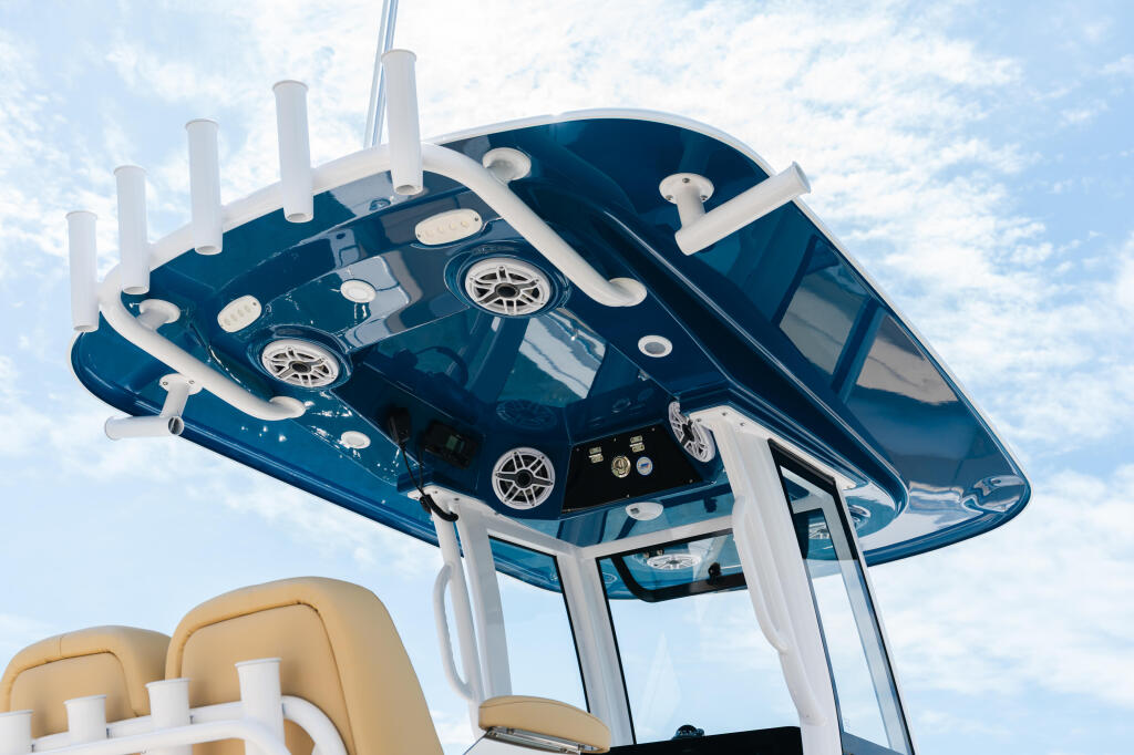 Overhead view of center console boat's hard-top with integrated white lighting, helm equipment, and tan seating visible below