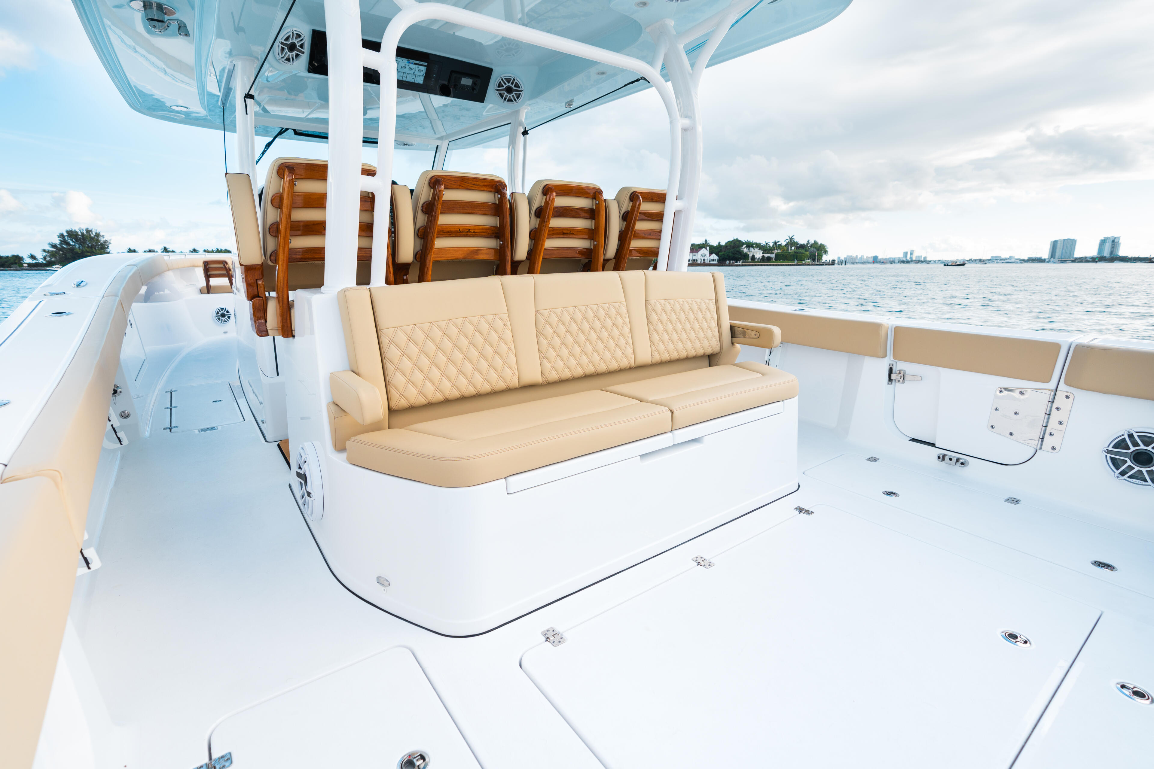 Open cockpit with tan quilted seating, white hard-top canopy, and water views on a center console boat