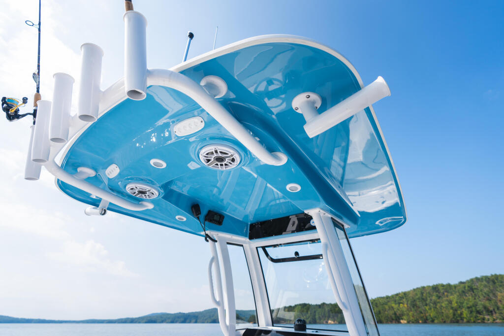 Overhead view of a blue and white center console boat with hard-top canopy featuring integrated lighting and multiple rod holders on a lake