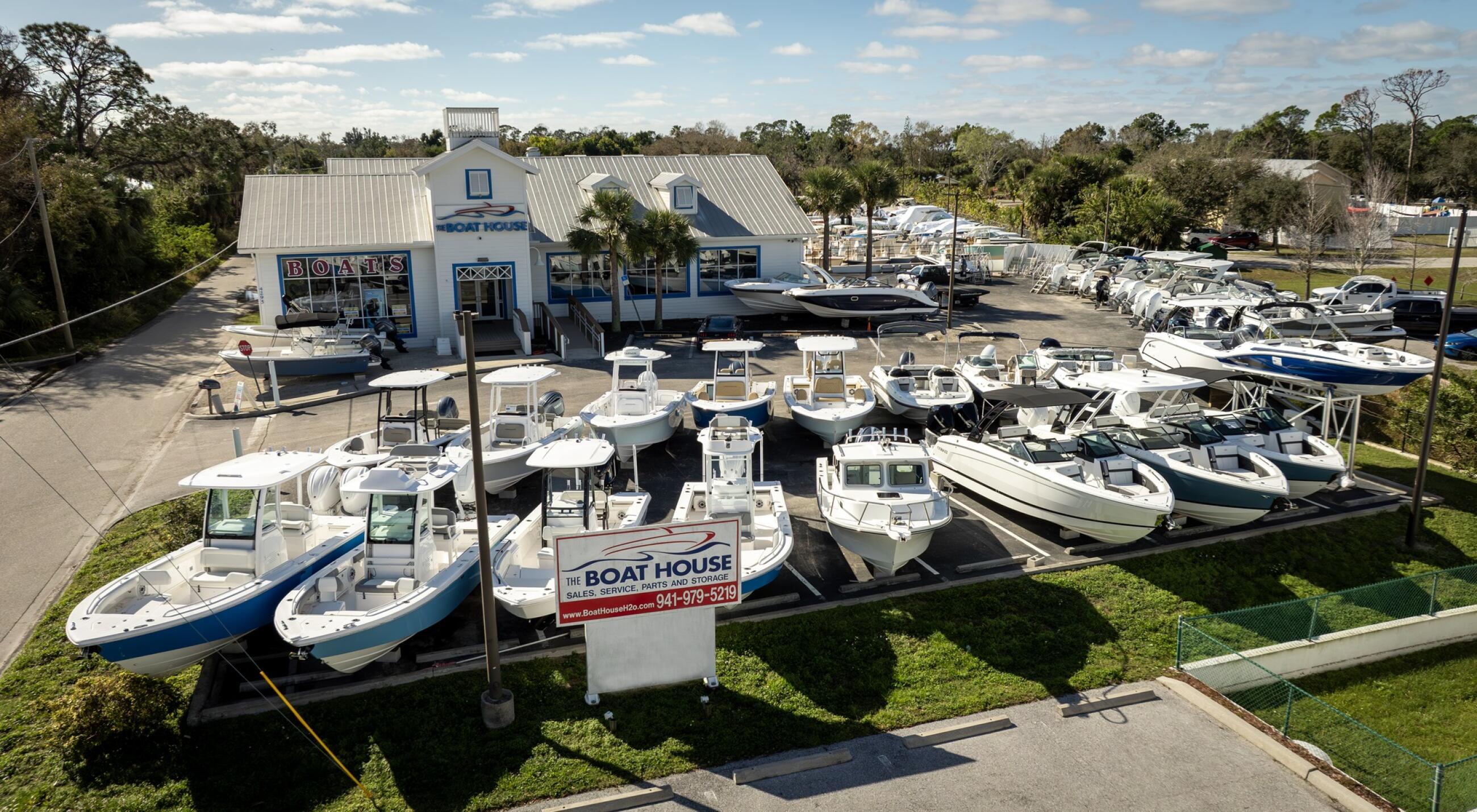 Aerial view of The Boat House dealership with multiple boats docked and displayed on the grounds in Port Charlotte, Florida