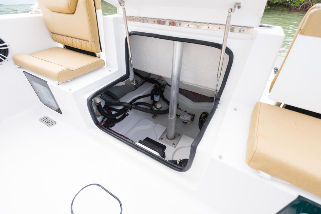 Center console boat's open rear hatch displaying engine compartment with mechanical systems and storage access