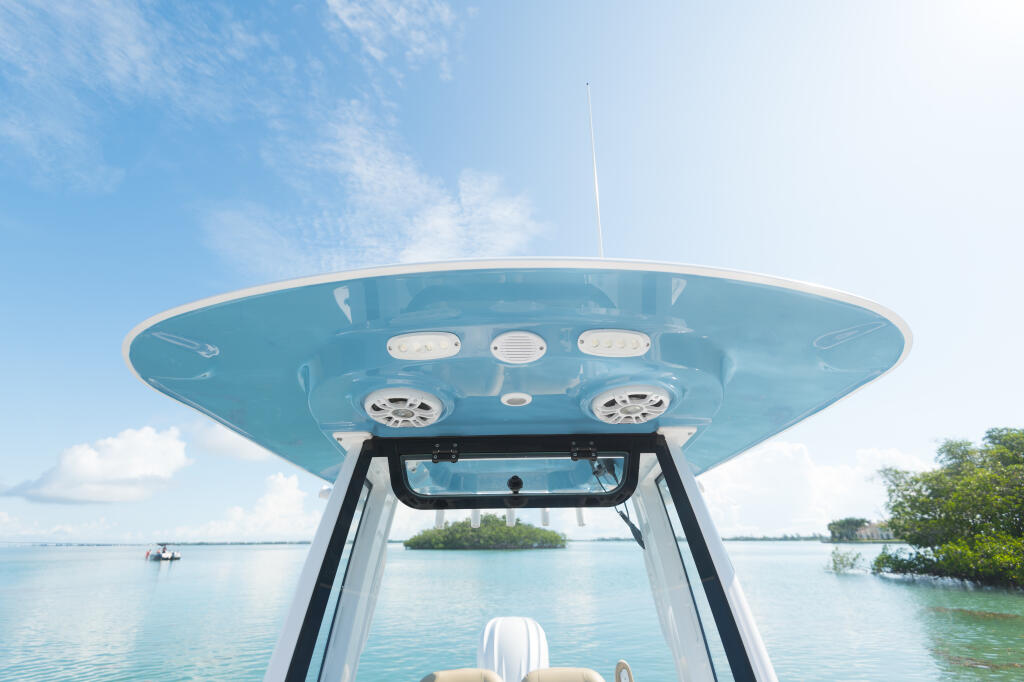 Overhead view of a turquoise center console hard-top with integrated lighting, speakers, and electronics against calm tropical waters