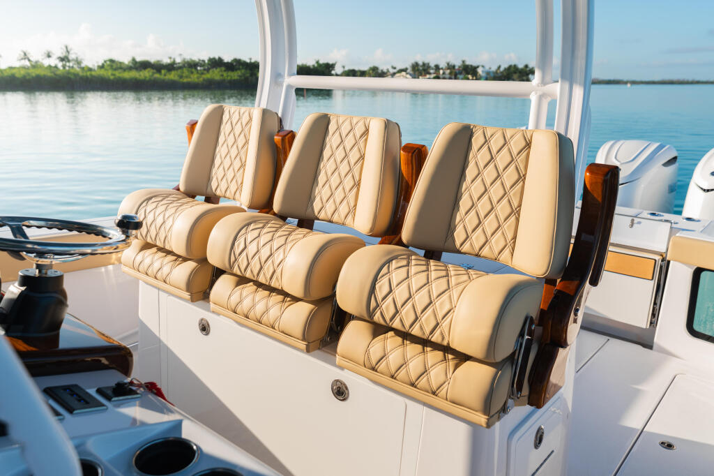 Luxurious cream and tan quilted seating with bolstered headrests on an open sportfish boat's console