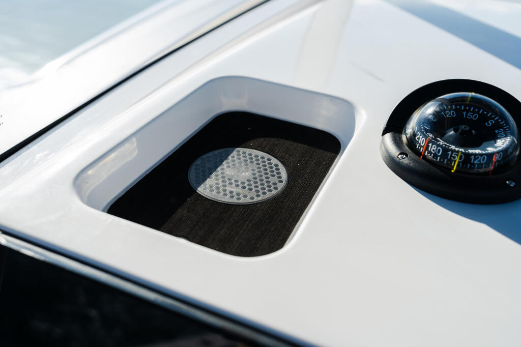 Boat helm features a compass and recessed storage compartment with anti-slip mat