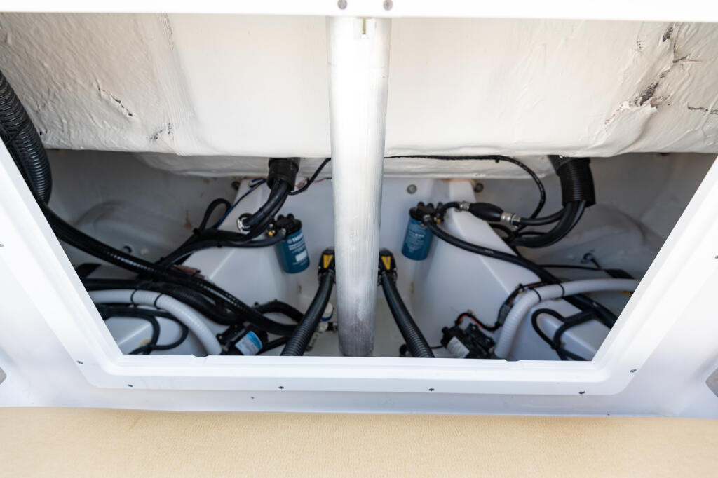 Open engine hatch revealing neatly organized fuel lines, filters, and electrical components with blue accent details