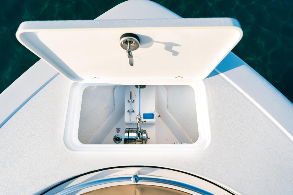 Overhead view of boat cabin showing helm station with fishing reel and electronics mounted inside