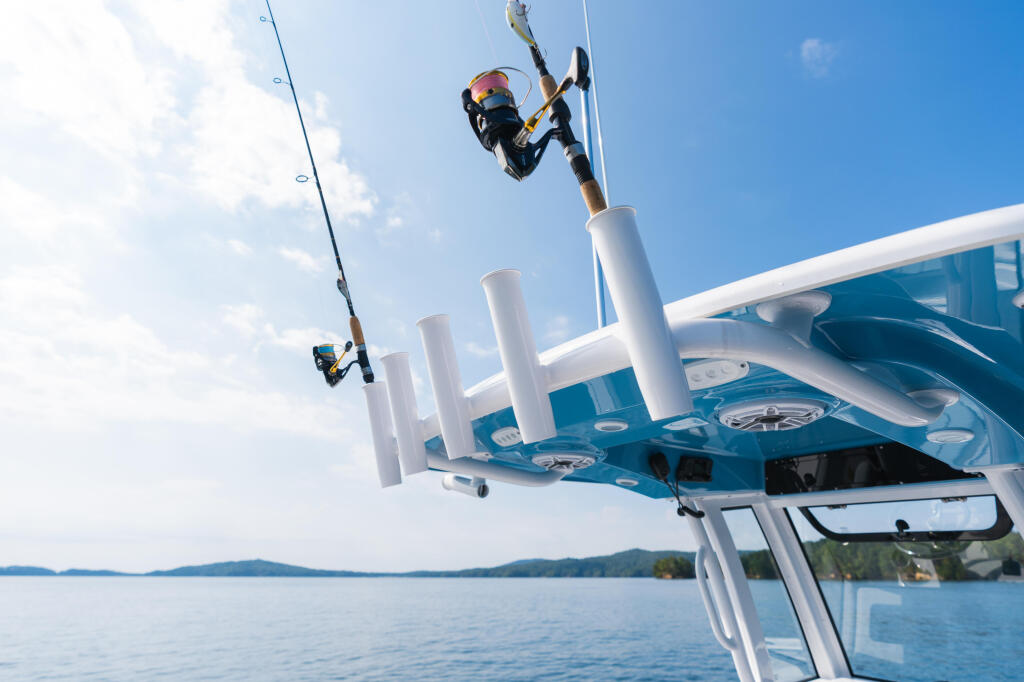 Angler fighting a fish from rocket launcher rod holders on center console boat with hard-top
