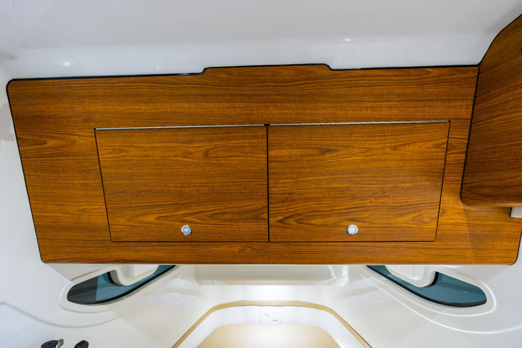 Wooden cabin storage with two drawers and chrome handles above windshield