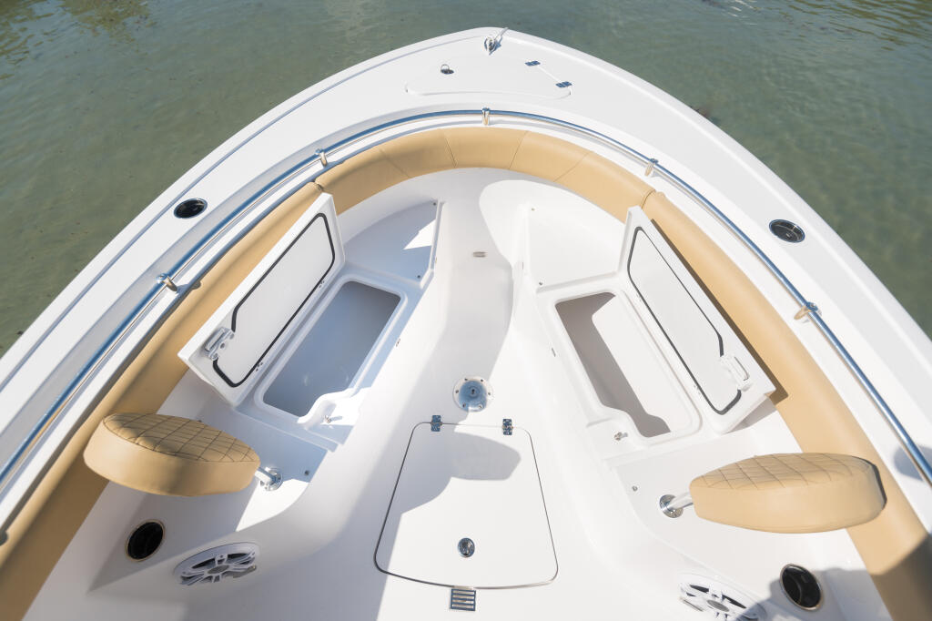 Overhead view of center console boat's bow seating area with tan cushioned seats and white fiberglass hull
