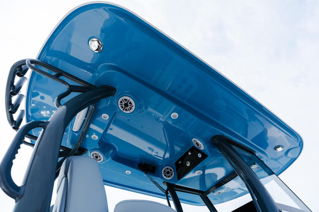 Blue hard-top boat windshield and helm structure with steering wheel and electronic controls visible from below