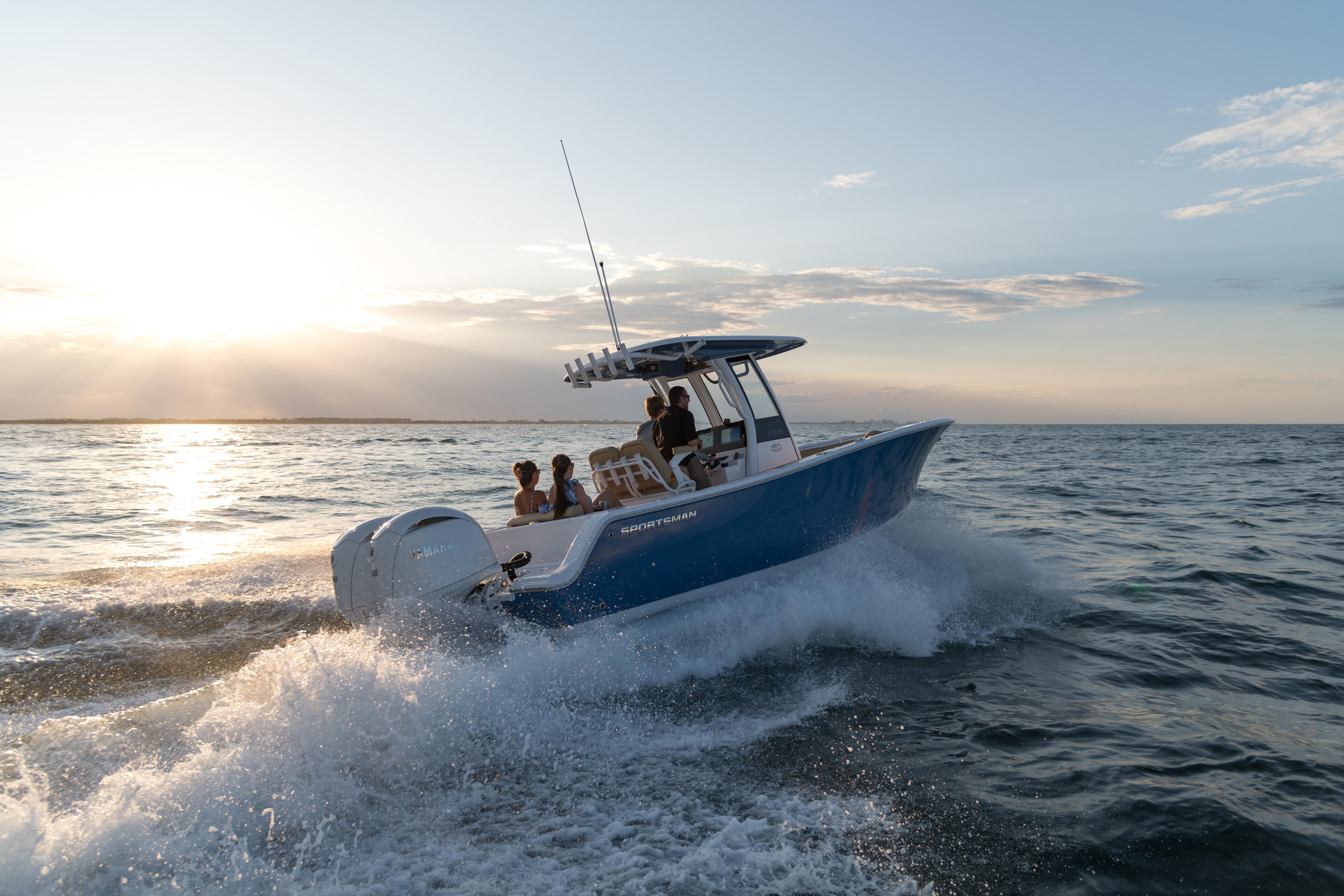Center console fishing boat with passengers cruising through beach waves at sunset