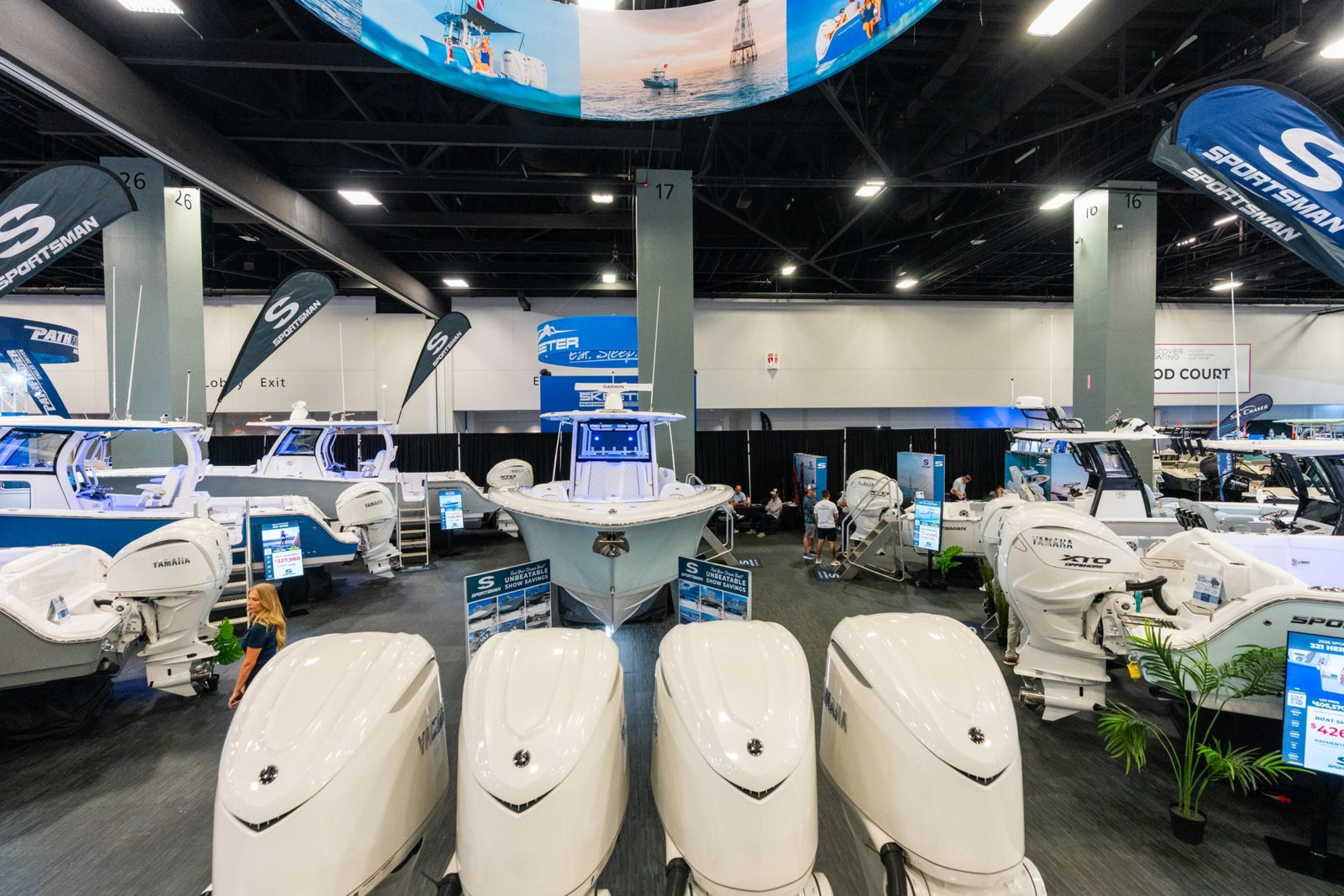 Boat showroom display with multiple white vessels and Yamaha engines under industrial lighting