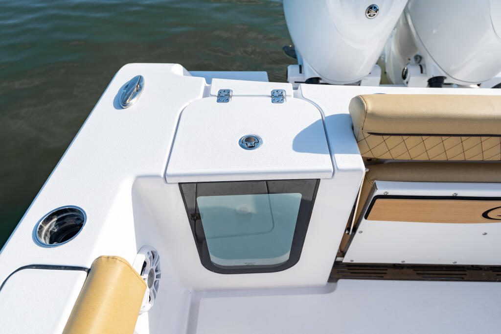 Center console boat deck with 25-gallon livewell, curved tan seating, and chrome hardware details
