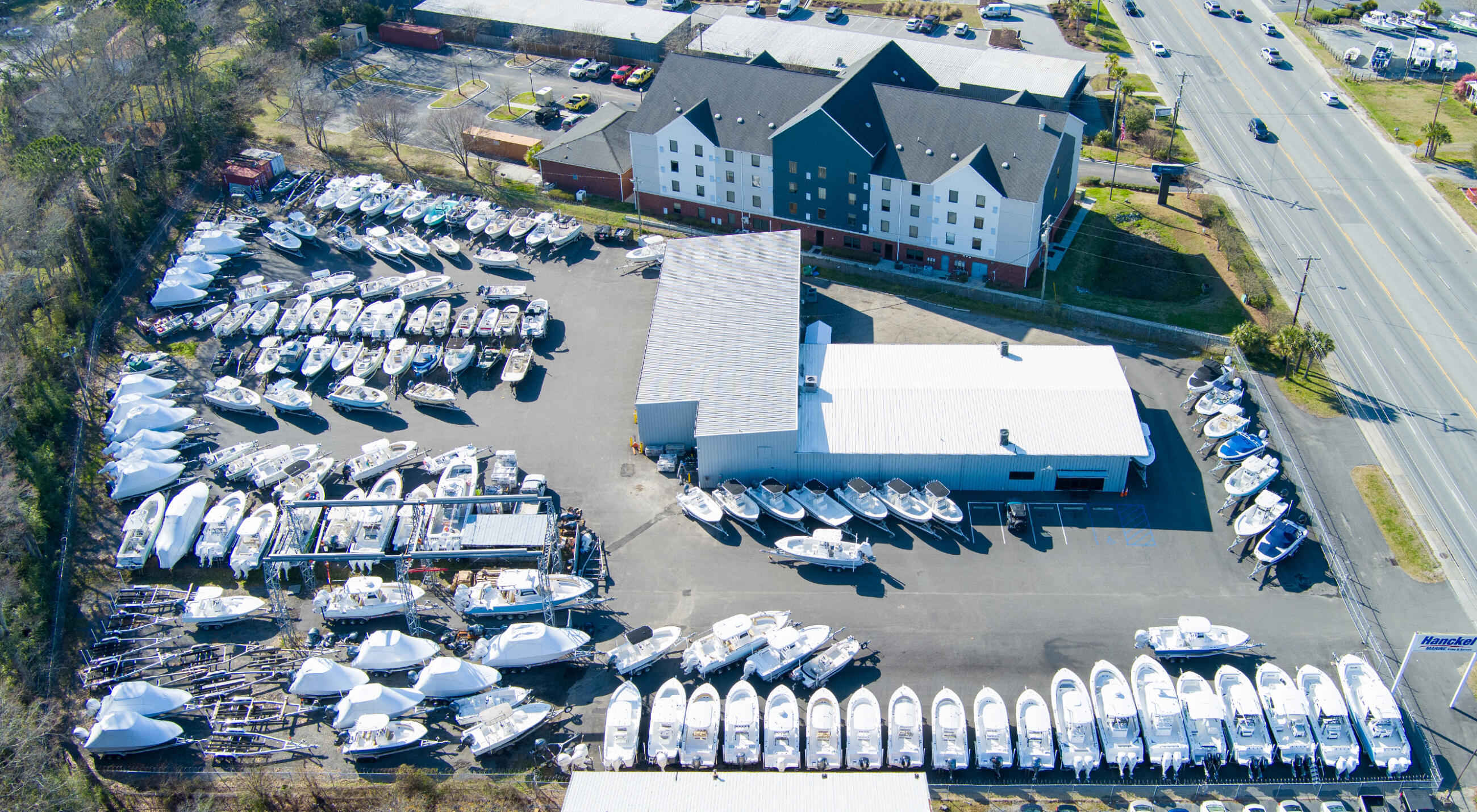 Aerial view of marina facility with rows of docked boats and waterfront buildings in Charleston
