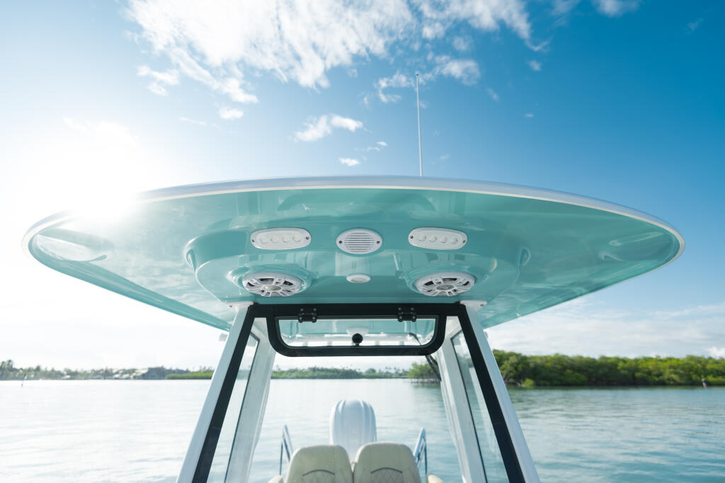 Underside view of a turquoise hard-top canopy on a center console boat with integrated lighting and ventilation