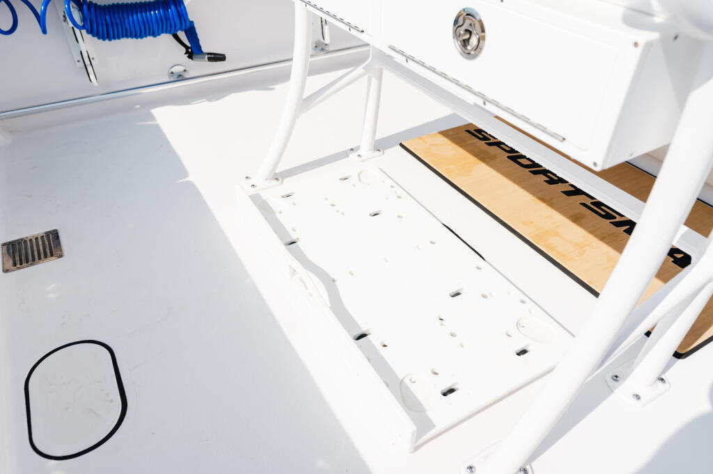 Open livewell with wooden inserts and black straps on a white fishing boat deck
