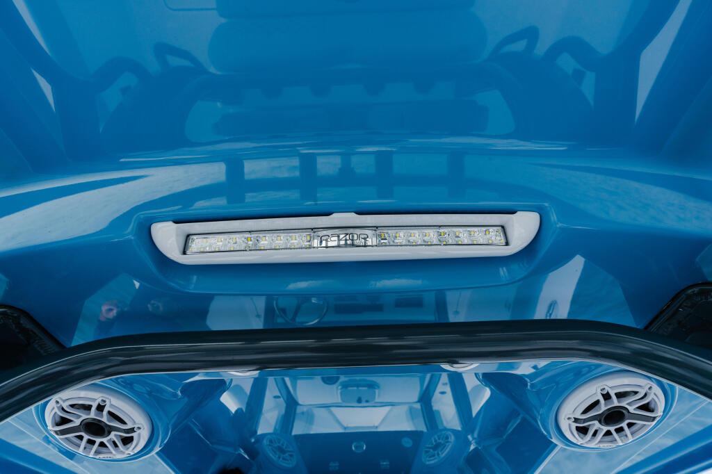 Blue boat helm with LED lighting strip and dual circular speakers mounted on windshield