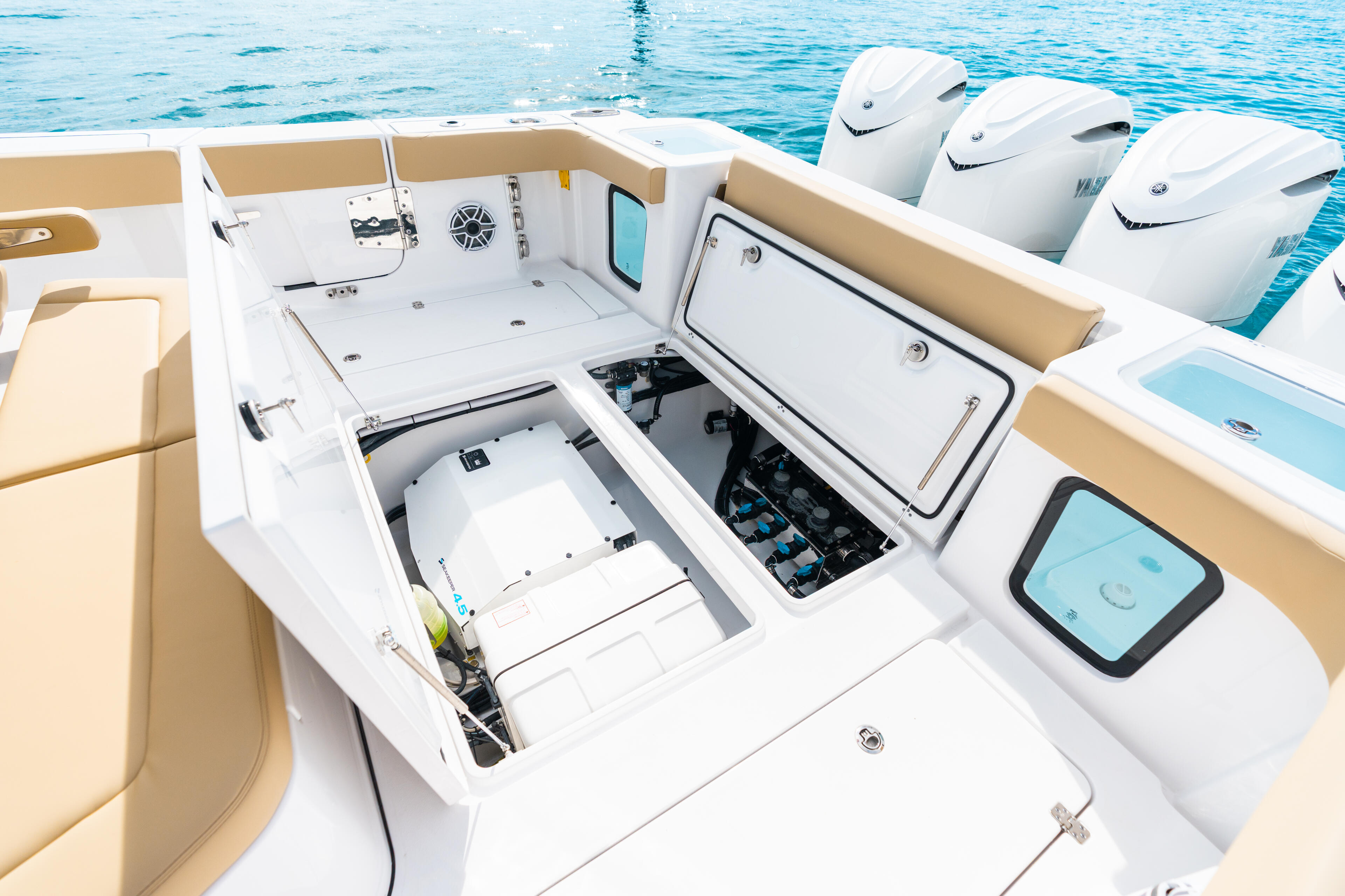 Overhead view of center console boat helm with open storage compartments revealing electronics and equipment