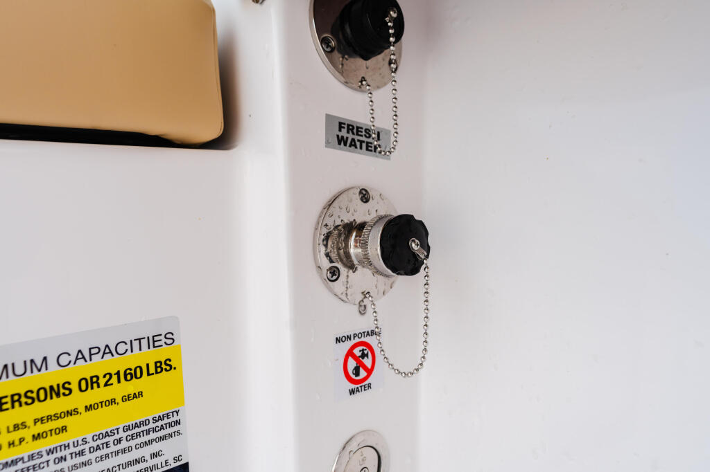 Boat freshwater and non-potable water fill valves with chain pulls and capacity label on white panel