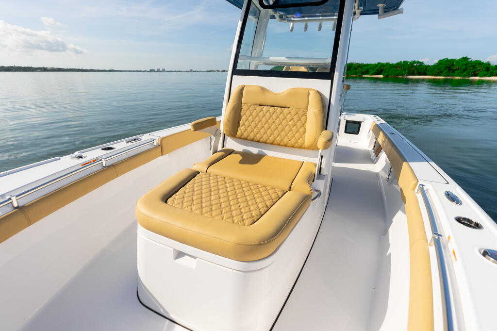 Spacious bow area with gold quilted seating and hard-top canopy on center console boat