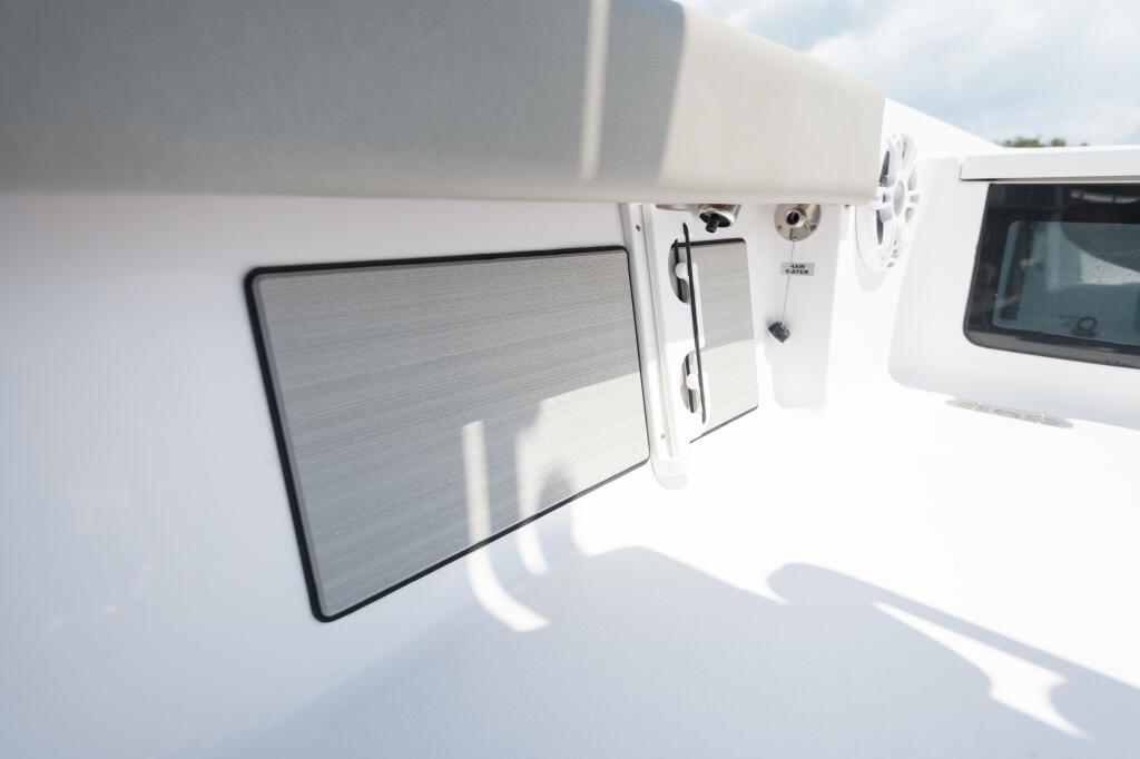 White boat console with electronics display screen and storage compartments visible on sunny day