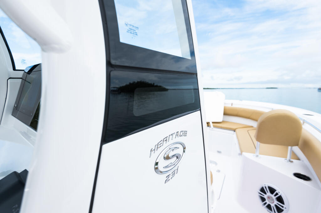 Heritage 231 center console boat with large tinted window and tan seating, anchored in calm coastal waters