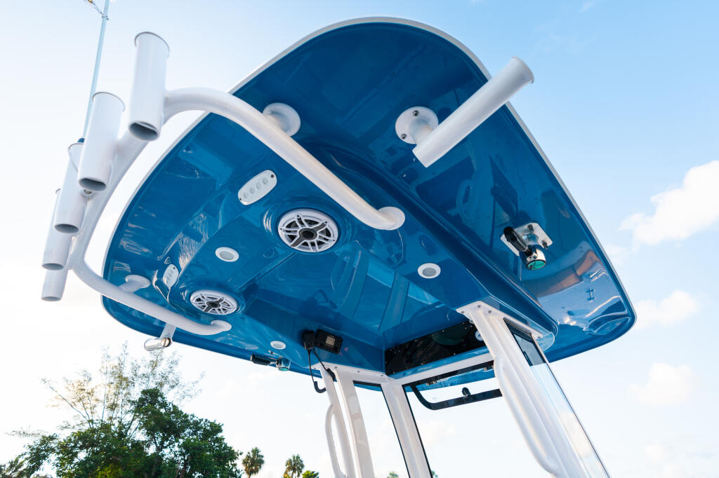 Overhead view of boat hard-top showing blue underside with white rails, speakers, and ventilation pipes