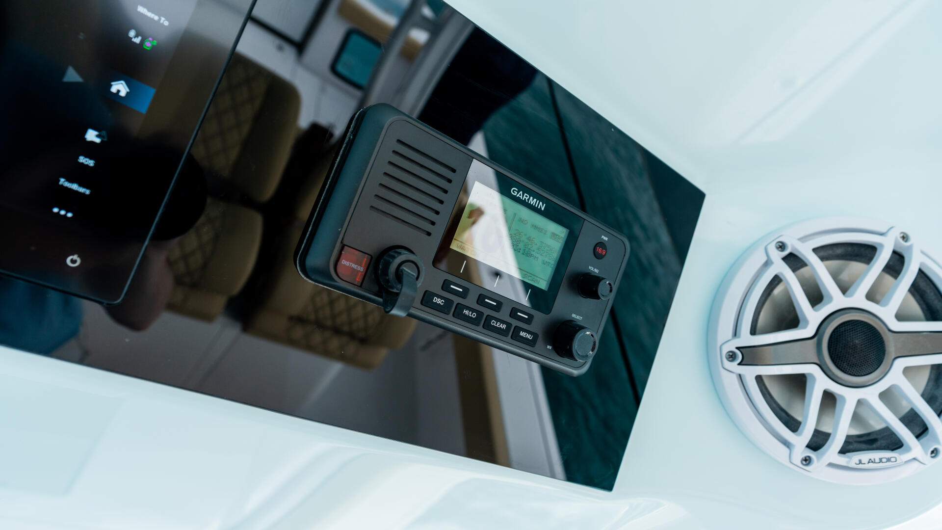 Helm console with Garmin chartplotter and audio speaker mounted on boat dashboard