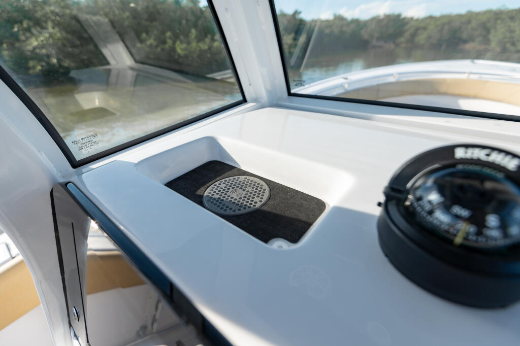 Wireless phone charger and compass mounted on the helm console with river view through windshield