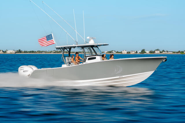 White center console boat with hard-top running at speed with family aboard near Florida coast