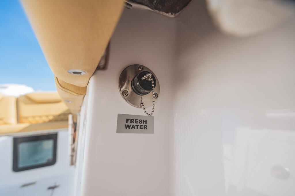 Fresh water valve with control knob on boat cabin wall, labeled for washdown system