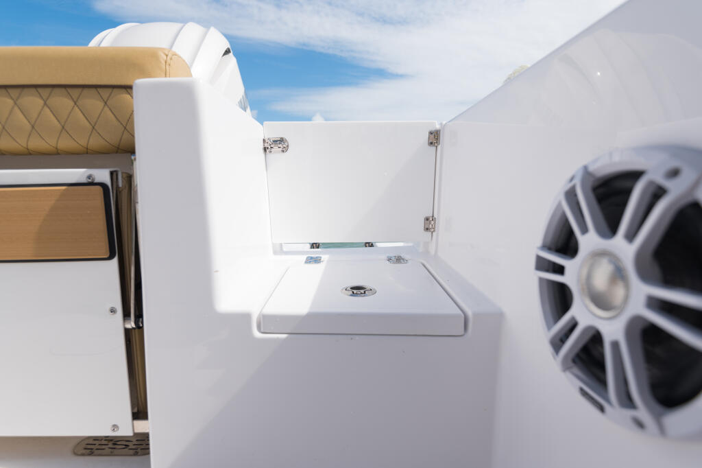 Transom door and storage compartment on boat with open hatch and speaker visible